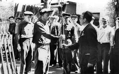 Работник райкома вручает оружие бойцам народного ополчения. Лето 1941 г.